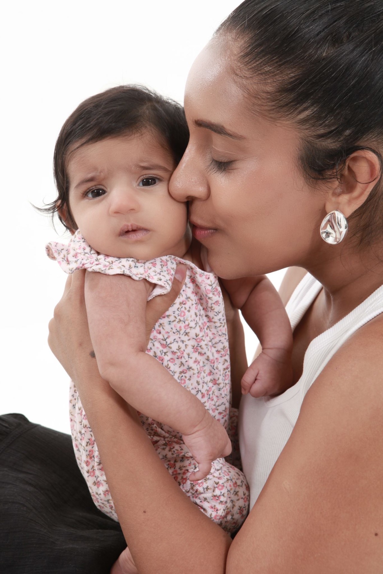 Misha of Kiki & Moon holding and kissing her baby daughter.